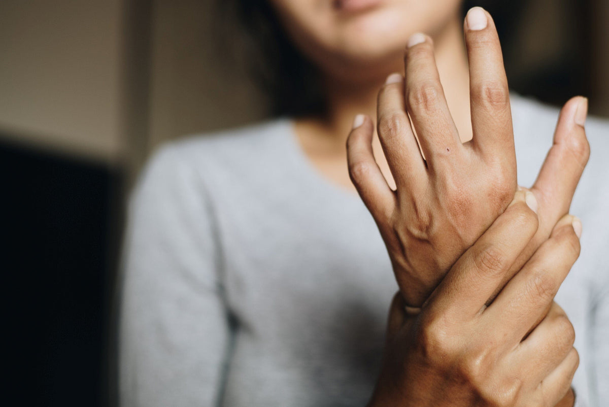 Woman with joint pain holding hand