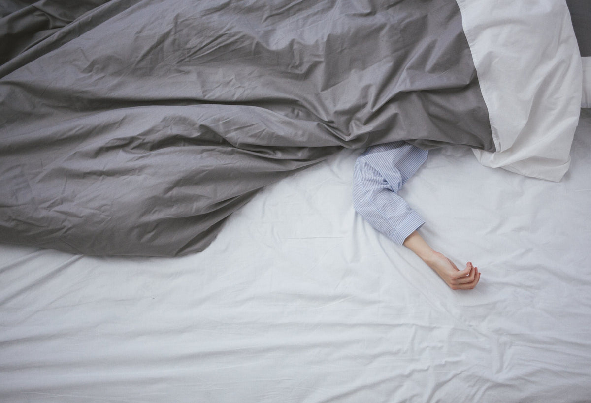 Person in bed with the covers pulled over them