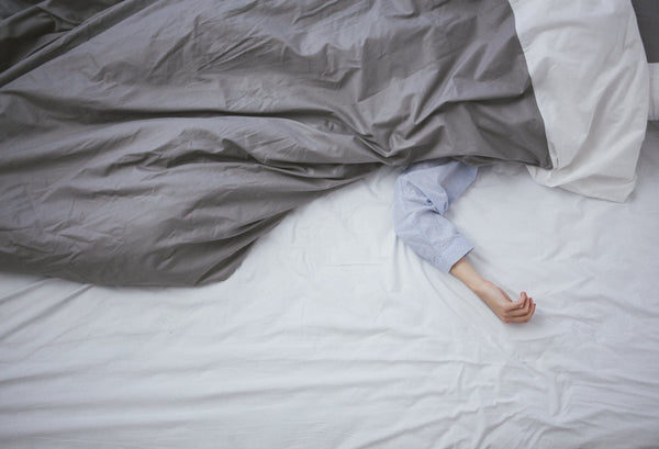 Person in bed with the covers pulled over them
