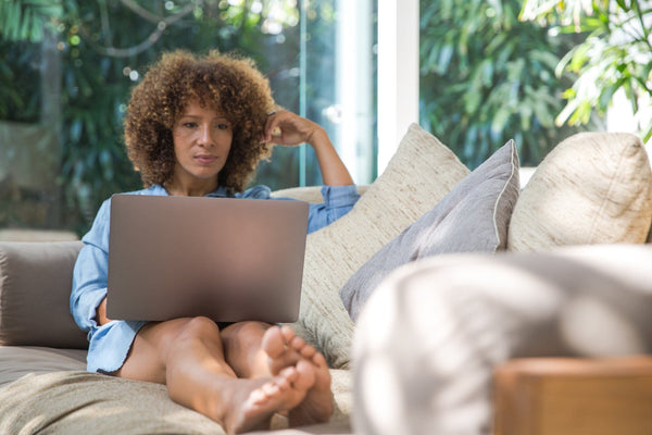 Woman sitting on couch with laptop