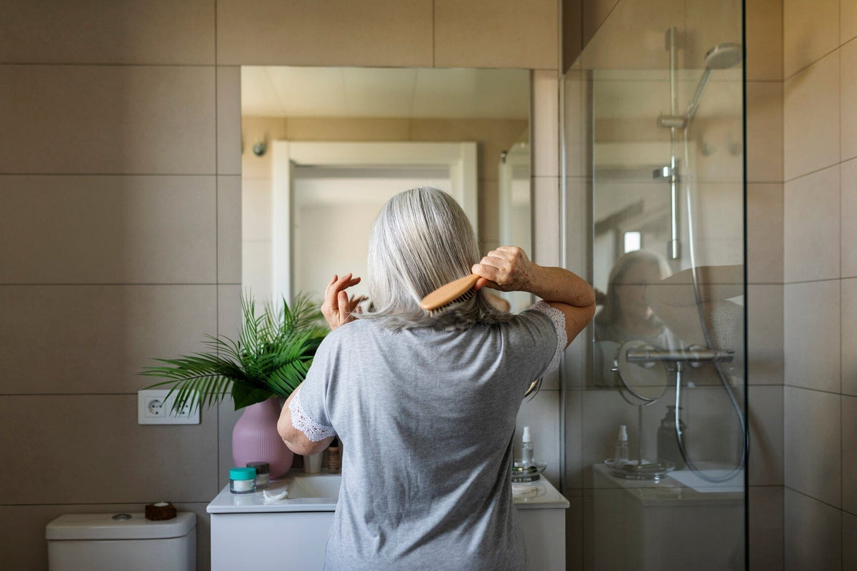 Woman brushing her hair in bathroom