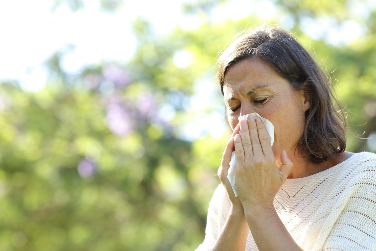 Woman sneezing outside