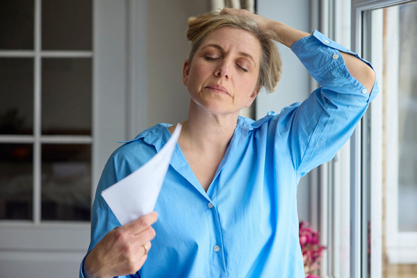 Woman fanning herself while holding hair up